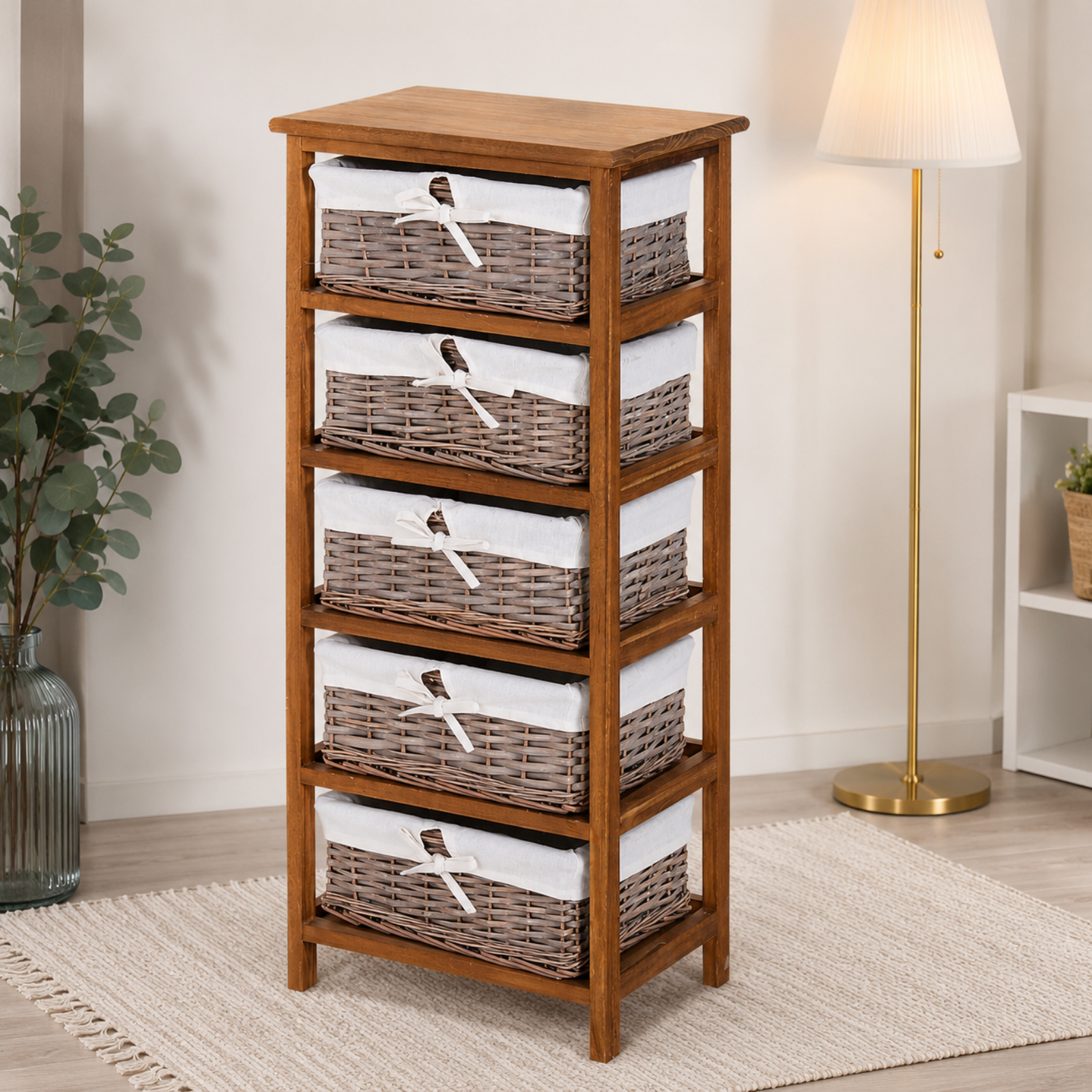 A 5-tier wooden storage chest with woven wicker drawers, each lined with white fabric and decorated with a small bird illustration, set in a styled room with a floor lamp, rug, and plant.