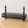 A black metal mesh desk organizer with adjustable vertical supports, shown on a light wood tabletop against a white fabric backdrop.