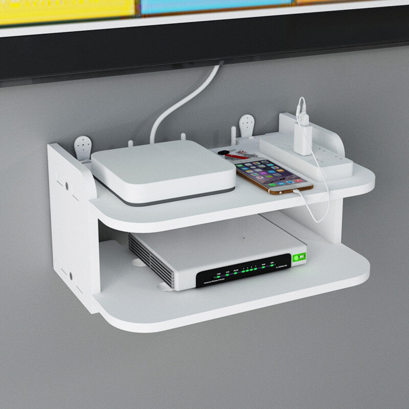 White wall-mounted shelf with electronic devices on a gray wall background