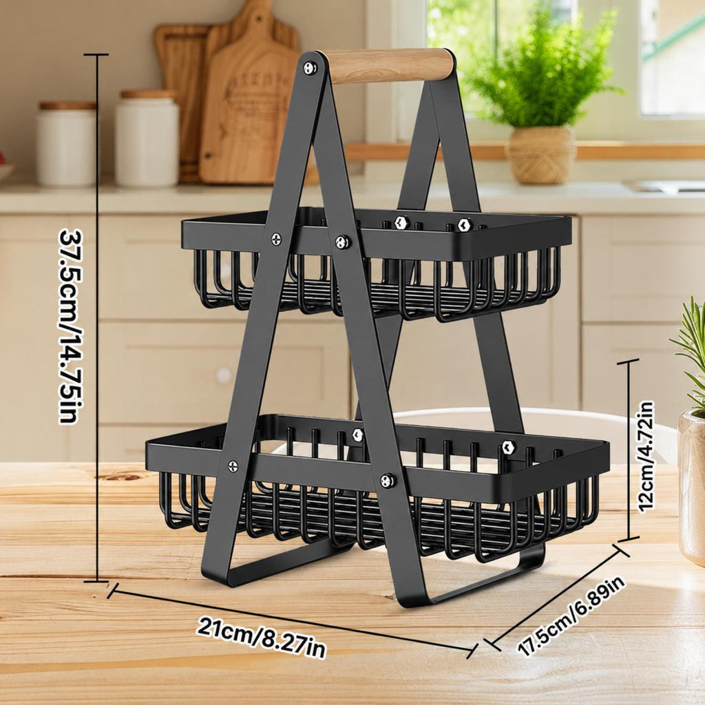 A two-tier black metal basket organizer with a wooden handle, shown on a wooden countertop in a kitchen setting with overlaid dimension lines and text indicating measurements.