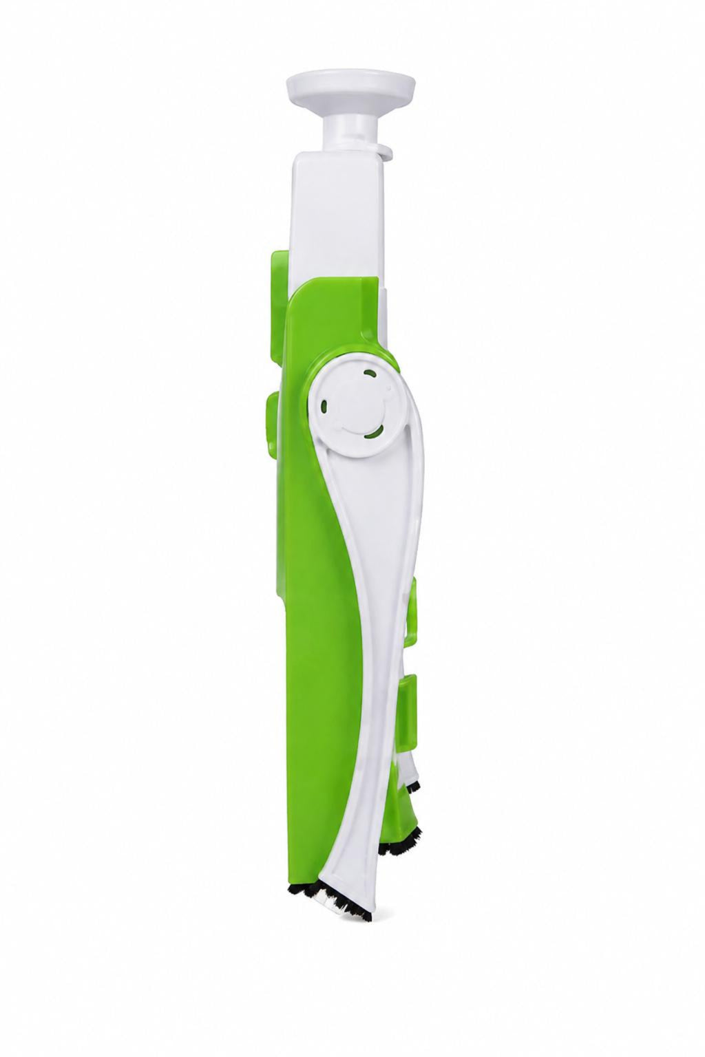 A green and white plastic kitchen utensil, likely a peeler or slicer, shown vertically against a plain white background.