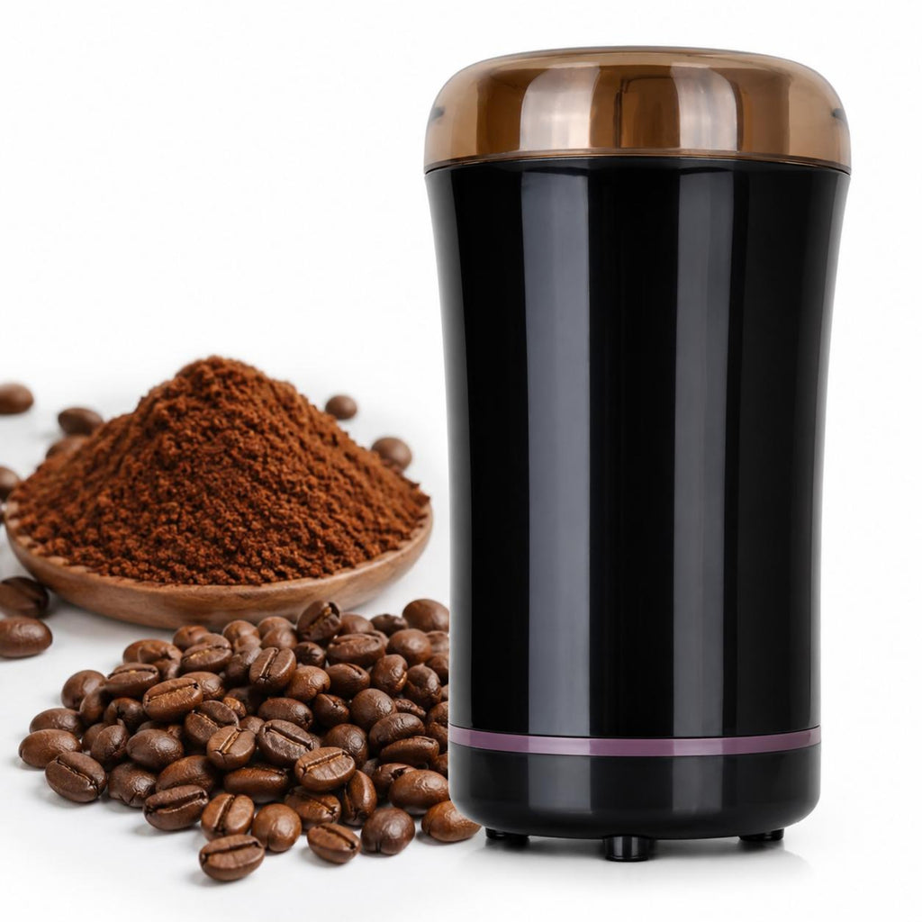 A black electric coffee grinder with a metallic bronze lid, shown next to a wooden bowl of ground coffee and scattered coffee beans on a white background.